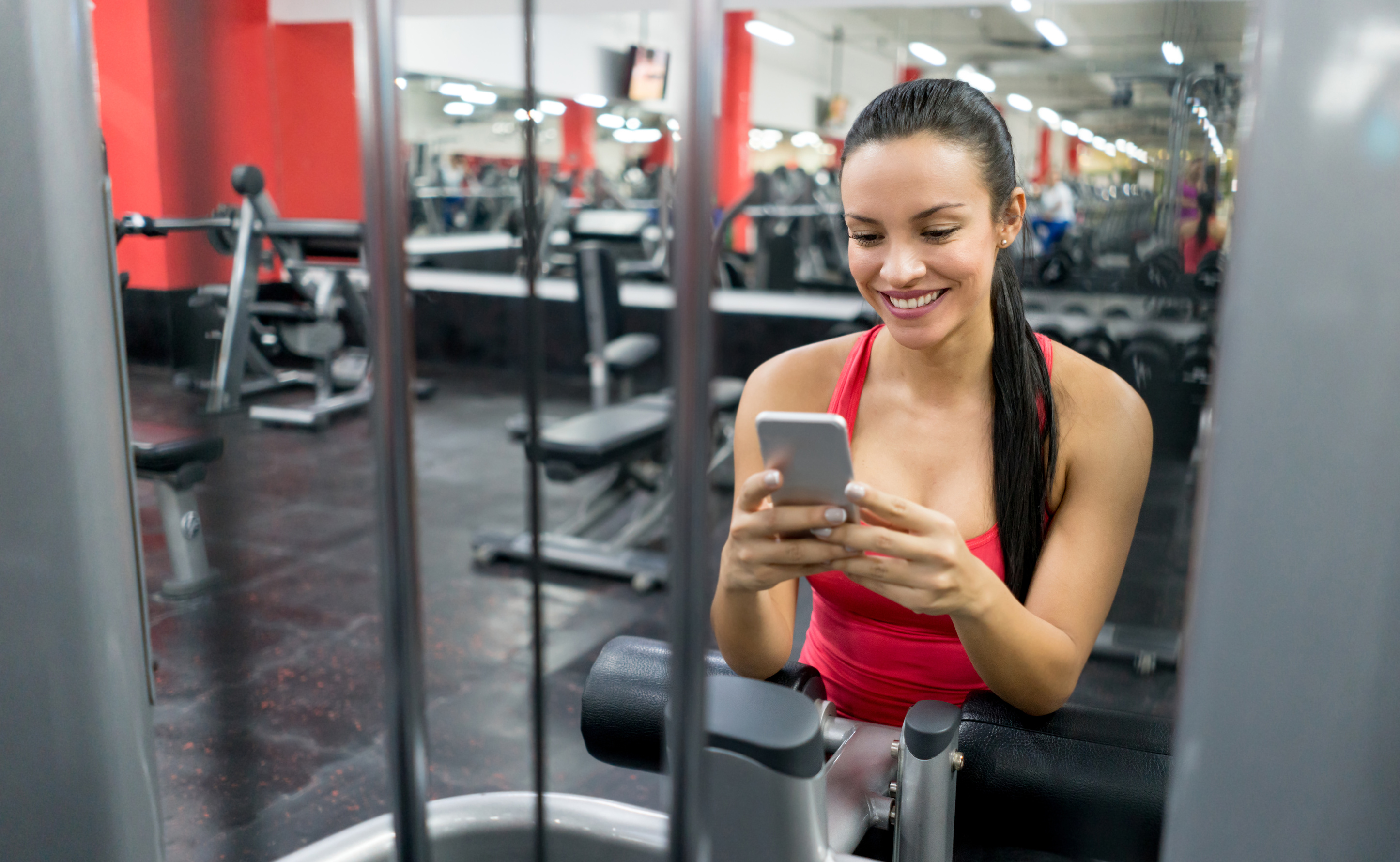 Woman at the gym texting on her cell phone